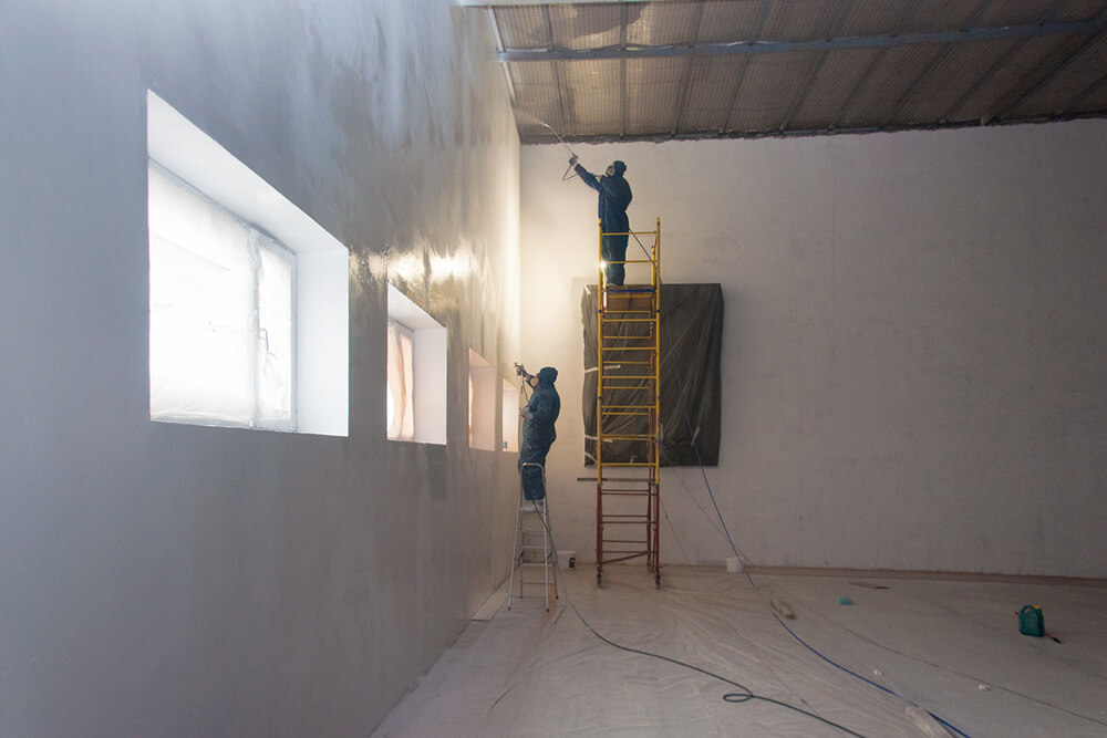 Рабочие красят стены склада